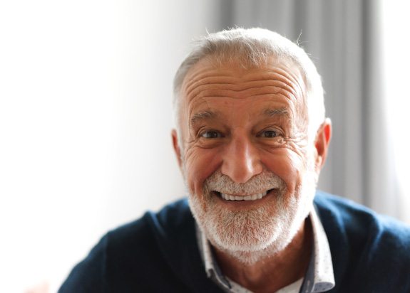 Bearded senior man in blue shirt smiling