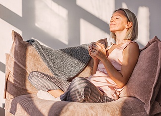 a woman relaxing on a couch drinking tea