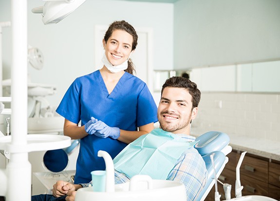 Dental assistant and patient smiling in treatment room